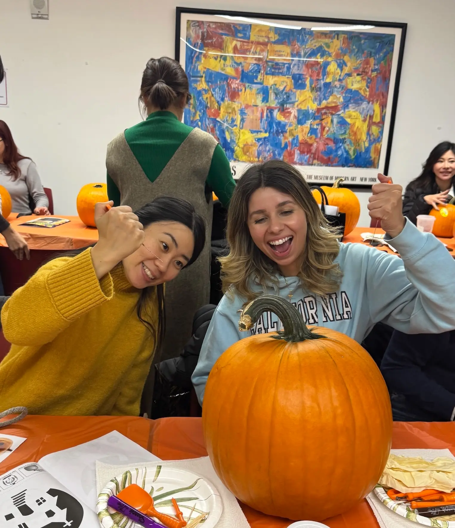 Rennert students carving a pumpkin during a fall activity in New York City.