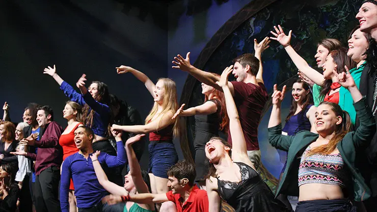 Students performing together on stage during an English plus acting program.