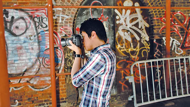 Student taking photos of street art during an English plus photography program in New York City.