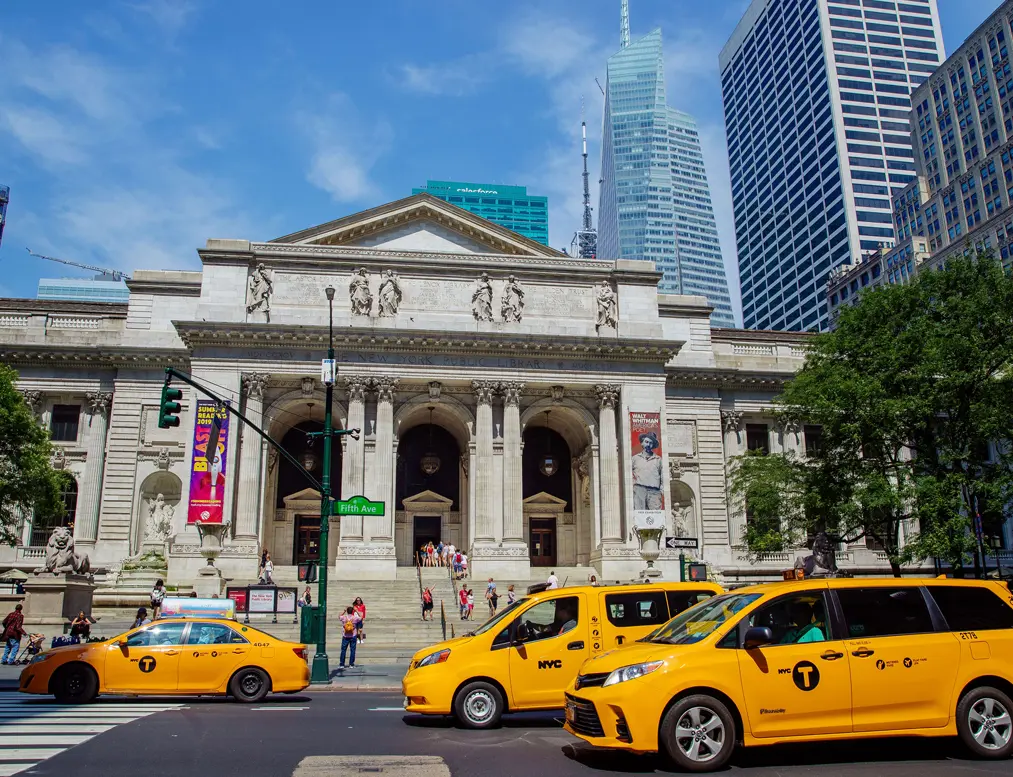 New York Public Library with yellow taxis in front, showcasing the vibrant city near Rennert's location.